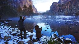Erick Jensen, left, of Seattle, and Ruth Reyes, right, of Los Angeles, prepare to photograph the sunset in Yosemite Valley Monday, Nov. 9, 2020, following the weekend's snowstorm in Yosemite National Park, Calif. Freezing weather gripped much of California early Tuesday morning in the aftermath of a weekend of rain and mountain snow. The National Weather Service says California was left with a dry, cold airmass as that storm system continued east, moving out of the Rockies into the Plains states. (Eric Paul Zamora/The Fresno Bee via AP)