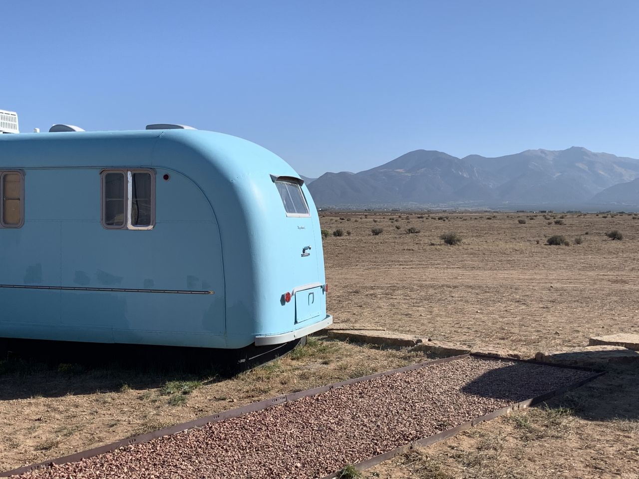 Vintage trailers are set against the Sangre de Cristo Mountains at Hotel Luna Mystica in Taos, New Mexico.