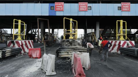 Workers clean up the Lekki toll gate, a site where soldiers had opened fire on protesters late on October 20, 2020