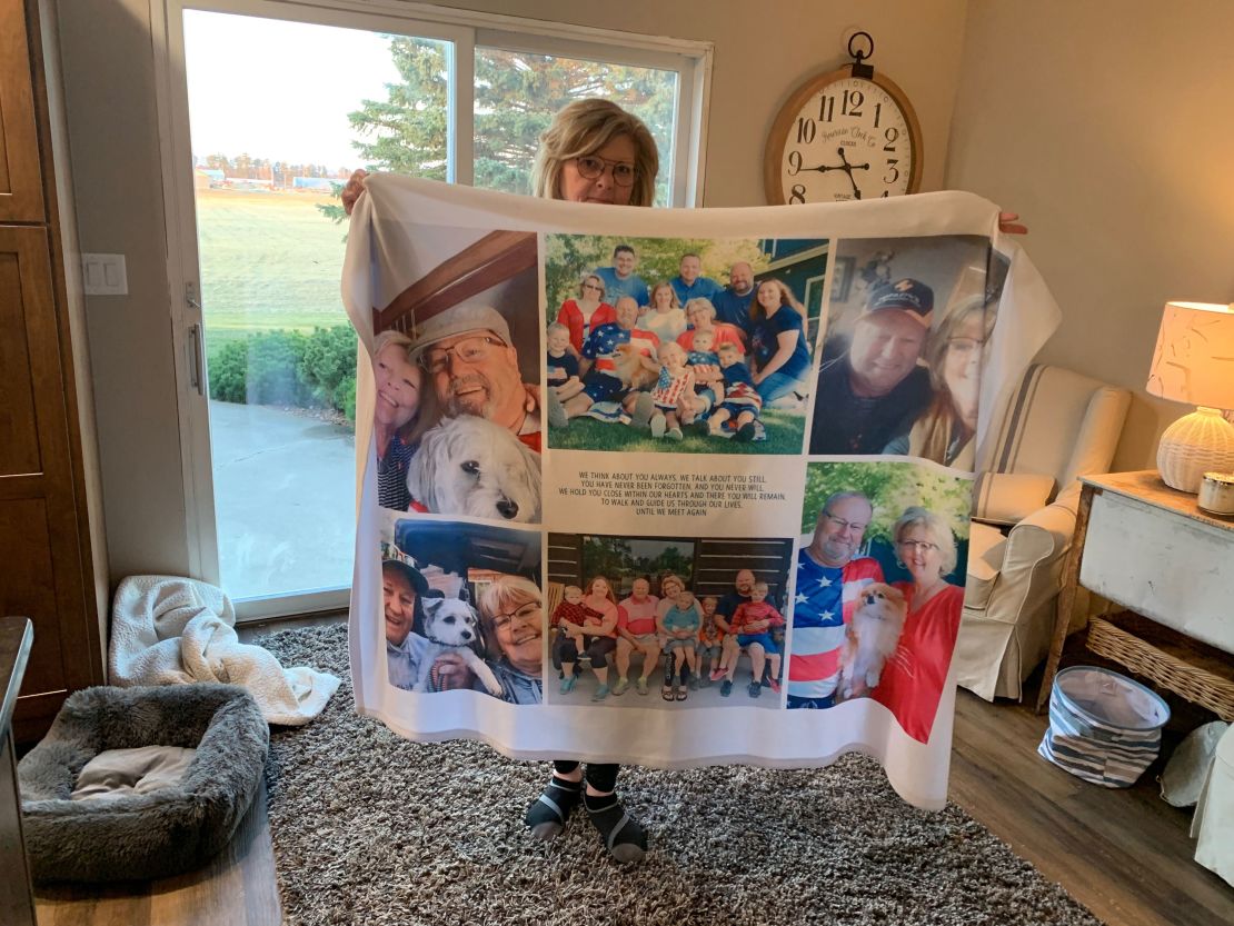 Chris Bjorkman holds up a quilt with photos of her late husband.