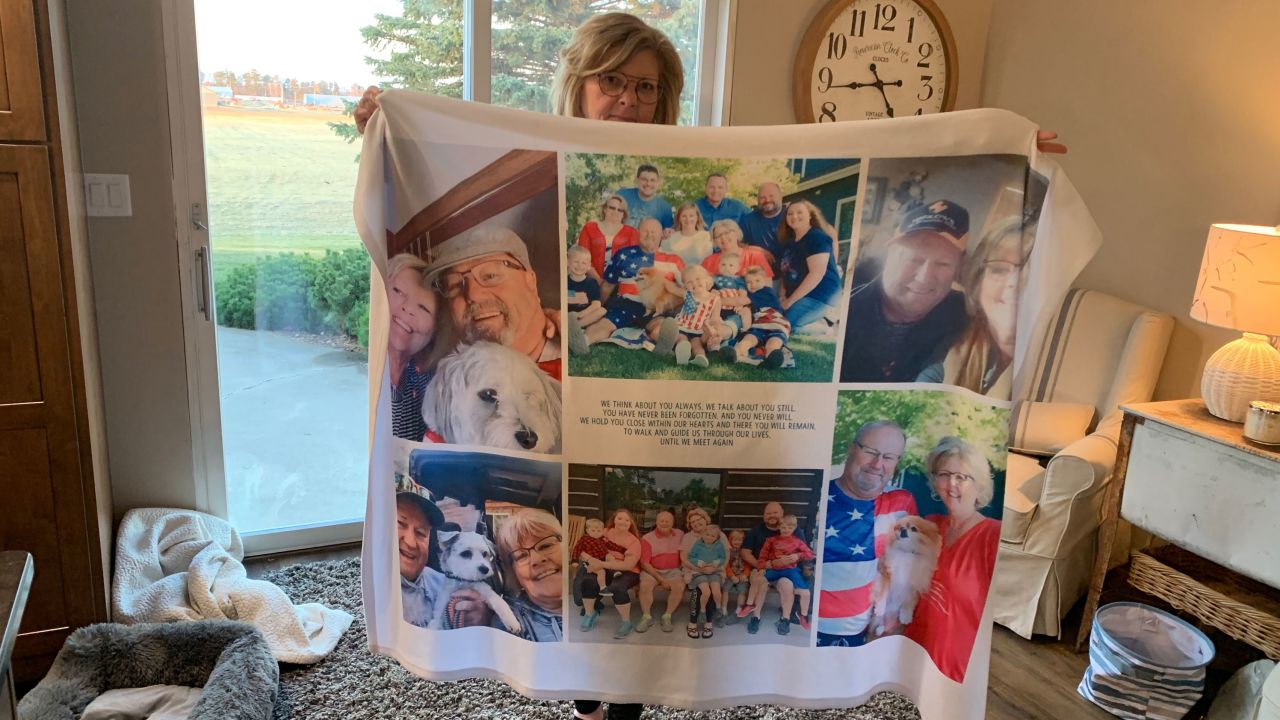 Chris Bjorkman holds up a quilt with photos of her late husband.