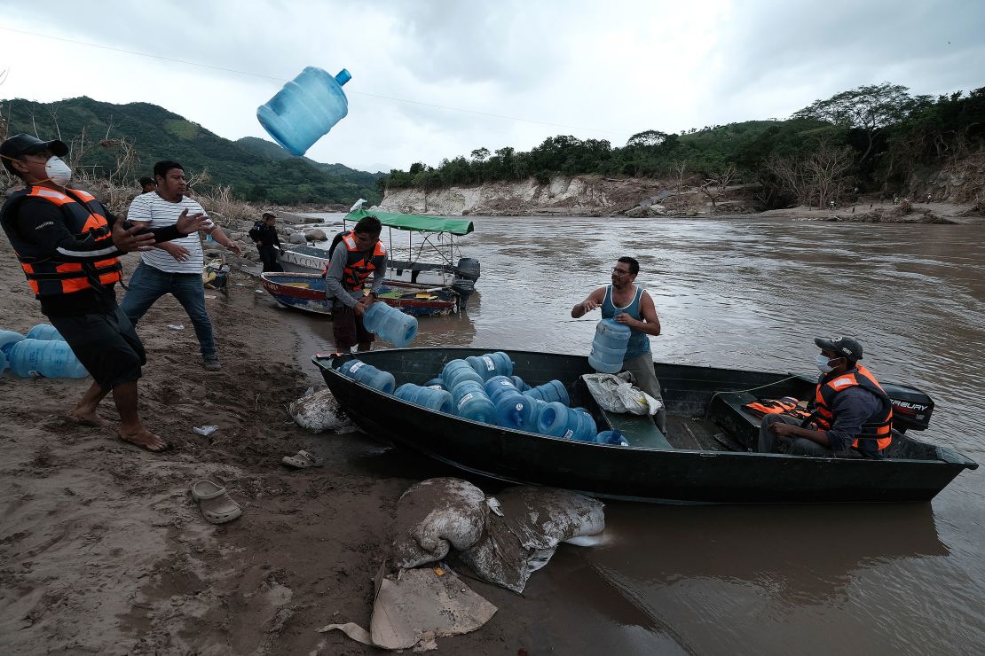 People from San Rafael colony in Honduras prepare for the water shortage as they cross the Ulua River to evacuate Monday. 