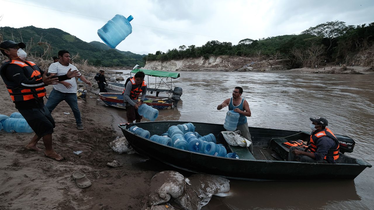 People from San Rafael colony in Honduras prepare for the water shortage as they cross the Ulua River to evacuate Monday.
