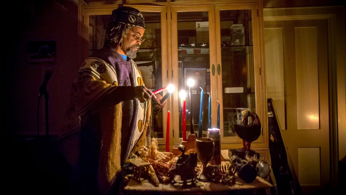 Mark Harris lights candles of the kinara, which represent the seven principals of Kwanzaa, in 2017.