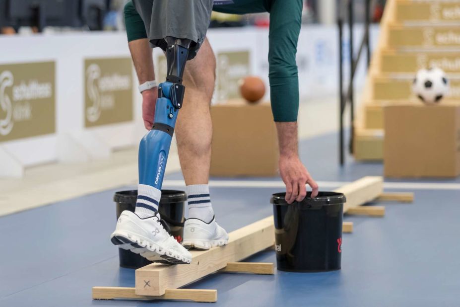 While balancing on a thin wooden beam, this pilot in the powered leg prosthesis race had to transport objects from one end of the beam to the other. This activity involves controlling and bending movements of the knee joint.