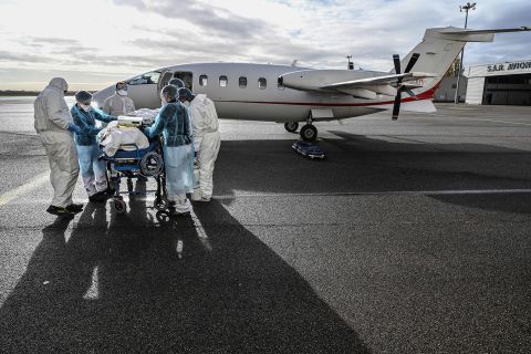 Medical staff transport a coronavirus patient to a waiting flight at the Lyon-Bron Airport in France on November 16.