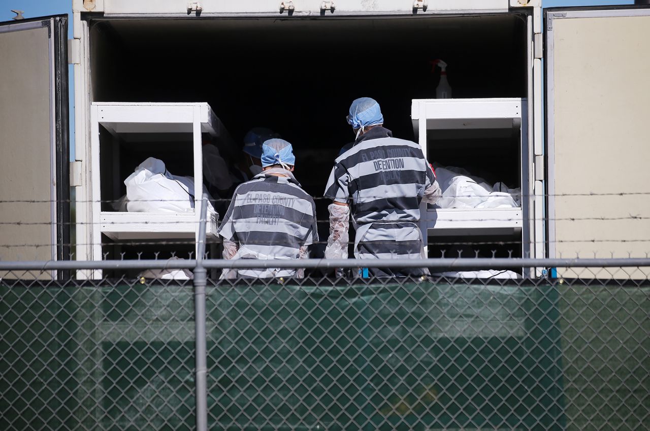 Low-level inmates from the El Paso County, Texas, detention facility, also known as "trustees," load bodies wrapped in plastic into a refrigerated trailer used as a temporary morgue outside of the El Paso County Medical Examiner's office on Monday, November 16. The United States surpassed <a href="https://www.cnn.com/2020/11/18/health/covid-19-deaths-us-250k-trnd/index.html" target="_blank">250,000 Covid-19 deaths</a> on Wednesday.