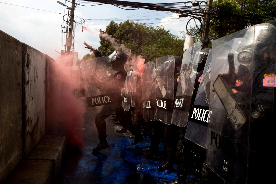 Riot police throw a smoke bomb back to pro-democracy protesters near the parliament in Bangkok, on November 17, 2020. 