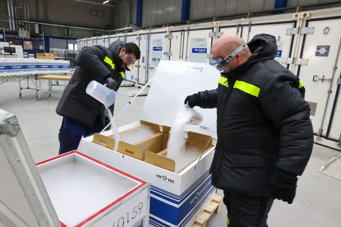 Employees fill a clinical and pharmaceutical product shipping box with dry ice at the Va-Q-Tec AG factory in Wurzburg, Germany, on November 18.