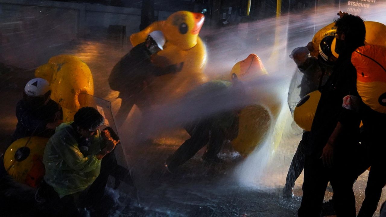 Demonstrators use inflatable rubber ducks as shields to protect themselves from water cannons during an anti-government protest outside the parliament in Bangkok, on November 17, 2020.