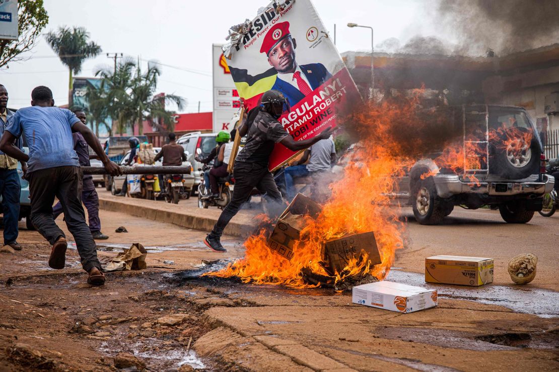A supporter of Bobi Wine carries his poster as they protest against his arrest in Kampala, Uganda, on November 18, 2020. 