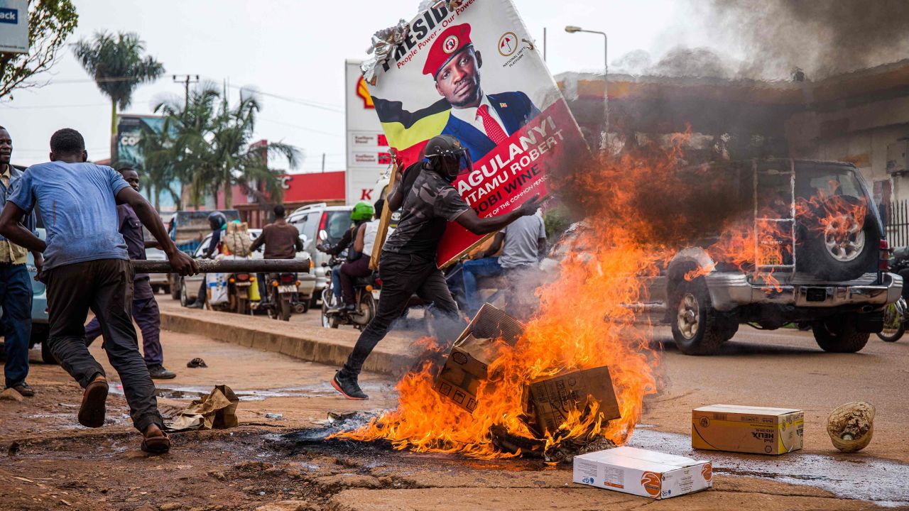 A supporter of Bobi Wine carries his poster as they protest against his arrest in Kampala, Uganda, on November 18, 2020.