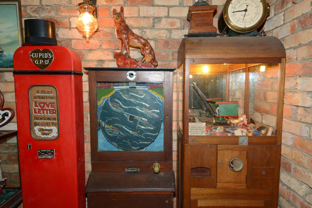 The Broughs' memorabilia included old-fashioned arcade machines. Here, a wooden claw machine can be seen on the right, filled with old toys. The claw was operated by hand, after depositing sixpence in the slot.