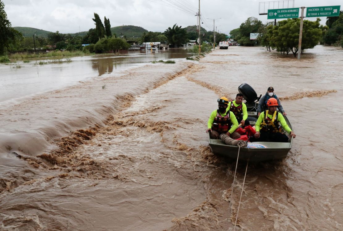 Rescuers navigate a flooded road in a boat after the passing of Hurricane Iota in La Lima, Honduras, Wednesday, Nov. 18, 2020.