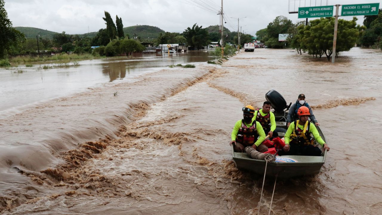 Rescuers navigate a flooded road in a boat after the passing of Hurricane Iota in La Lima, Honduras, Wednesday, Nov. 18, 2020.