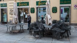A man wearing a face mask to curb the spread of the new coronavirus walks past a closed cafe, in Turin, northern Italy, Friday, Nov. 6, 2020. Piedmont is among the four Italian regions classified as red zones, where a strict lockdown was imposed starting Friday - to be reassessed in two weeks - in an effort to curb the COVID-19 infections growing curve. From today, bars and restaurants can only work with take-away customers. (Nicolo' Campo/LaPresse via AP)