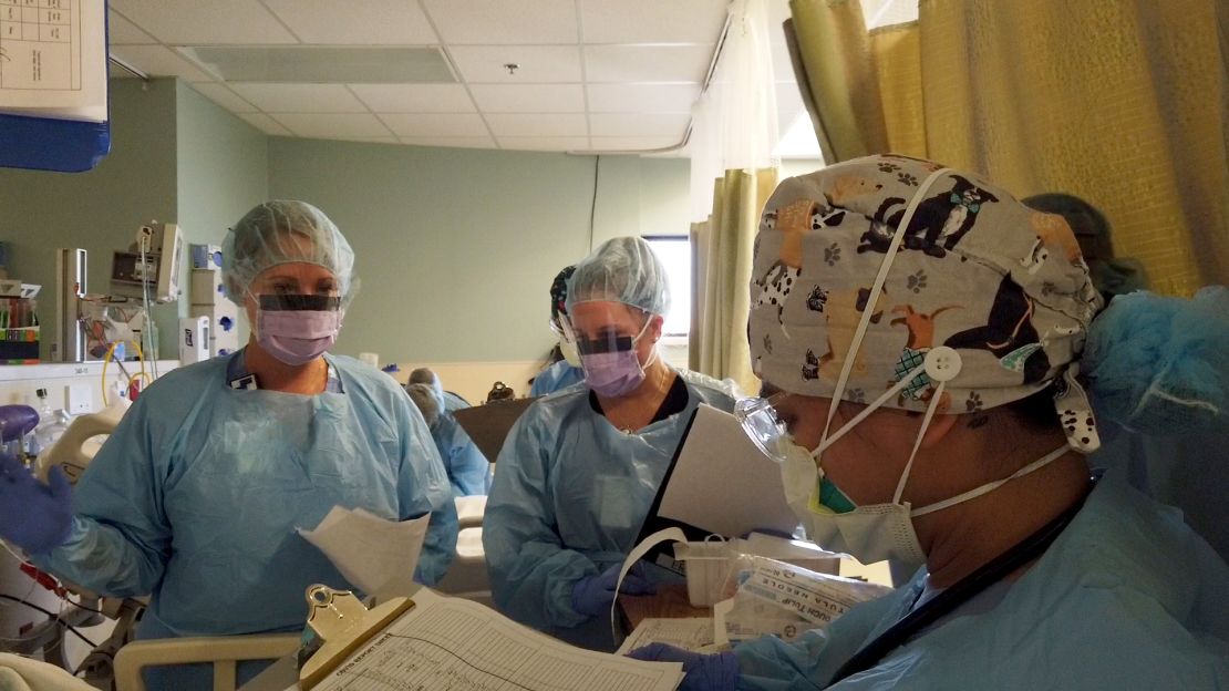 Denise Mourning confers with other staff in the crowded Covid-19 emergency room.