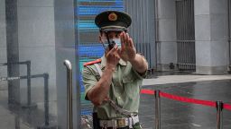 A Chinese paramilitary police officer gestures and speaks over his two-way radio whlie standing at the entrance gate of the Australian embassy in Beijing on July 9, 2020. - Australia on July 7 warned its citizens they could face "arbitrary detention" if they travel to China, the latest sign of growing tensions between the two nations. (Photo by NICOLAS ASFOURI / AFP) (Photo by NICOLAS ASFOURI/AFP via Getty Images)