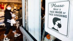 A shopper passes a sign urging customers to wear masks at a Brandy Melville store on Wednesday, Oct. 21, 2020, in San Francisco. As the coronavirus pandemic transforms San Francisco's workplace, legions of tech workers have left, able to work remotely from anywhere. Families have fled for roomy suburban homes with backyards. The exodus has pushed rents in the prohibitively expensive city to their lowest in years. (AP Photo/Noah Berger)