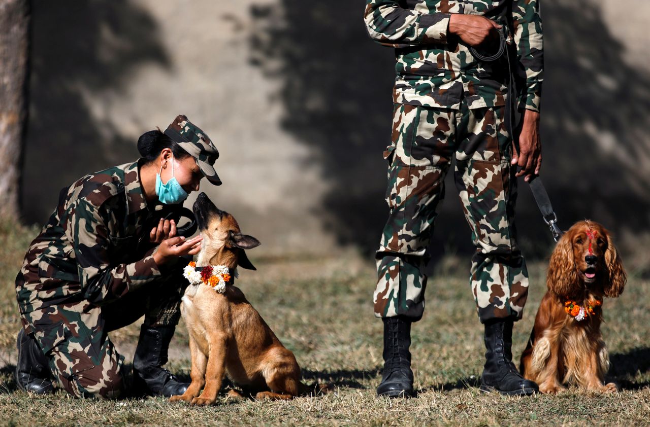 A member of the Nepali army pets her dog at the dog festival in Bhaktapur, Nepal, on Saturday, November 14.