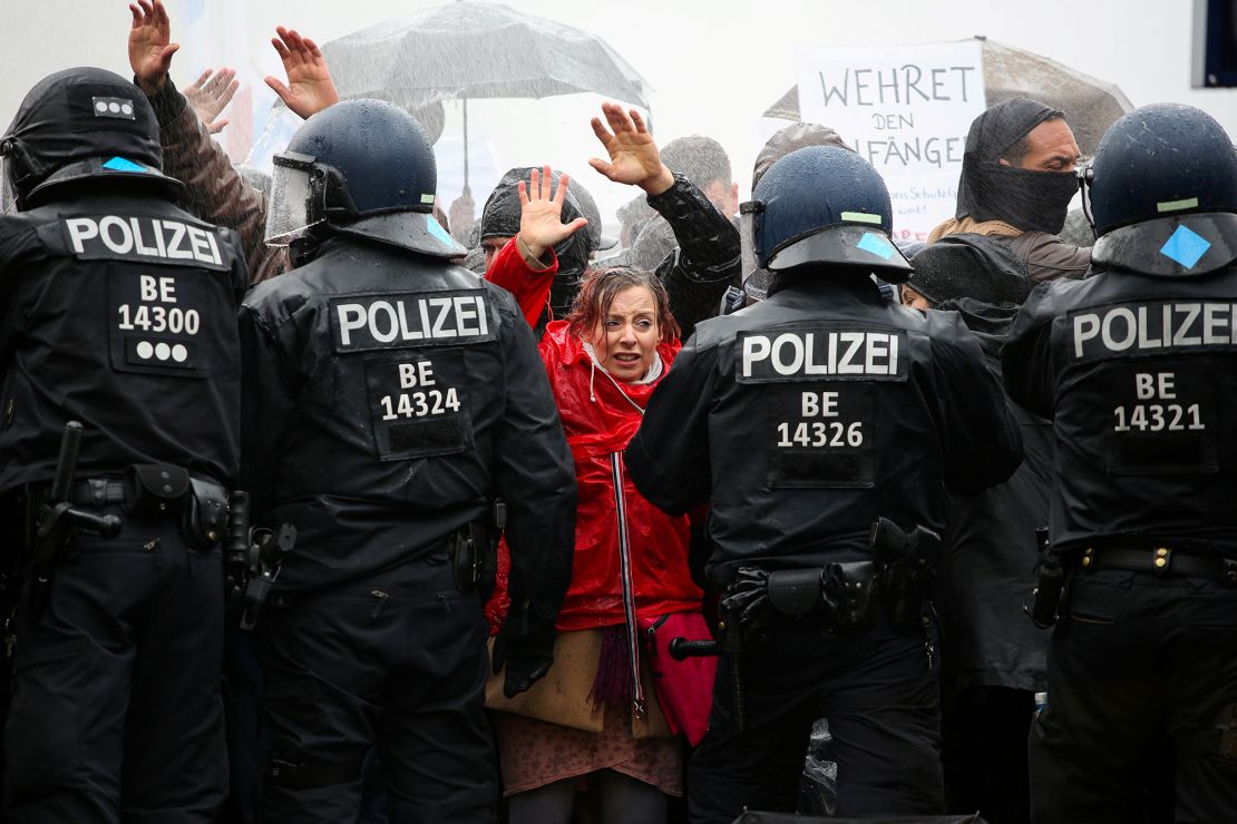 Demonstrators put up their hands in front of police officers during a protest against the government's coronavirus restrictions in Berlin, November 18, 2020.
