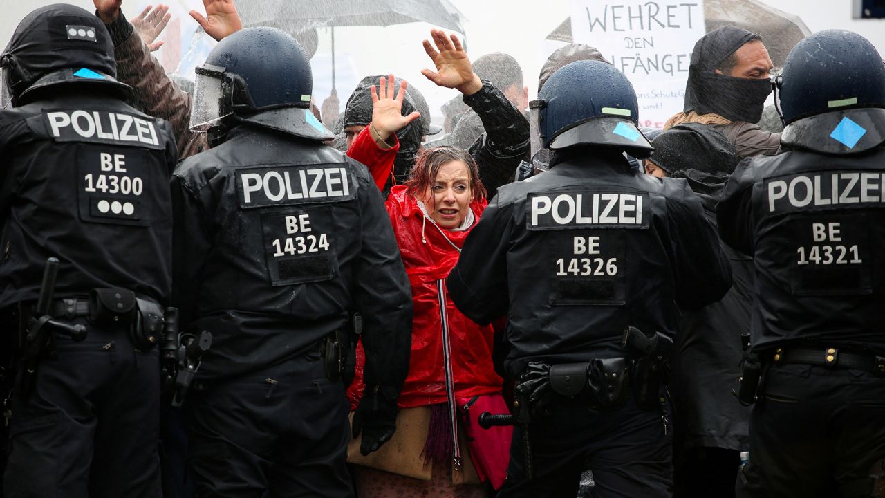 Demonstrators put up their hands in front of police officers during a protest against the government's coronavirus restrictions in Berlin, November 18, 2020.