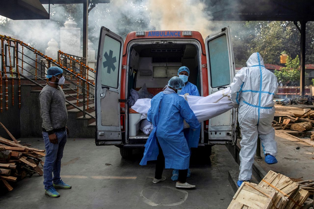 Health workers carry the body of a man who died of Covid-19 to a crematorium in New Delhi, India, on Friday, November 13.