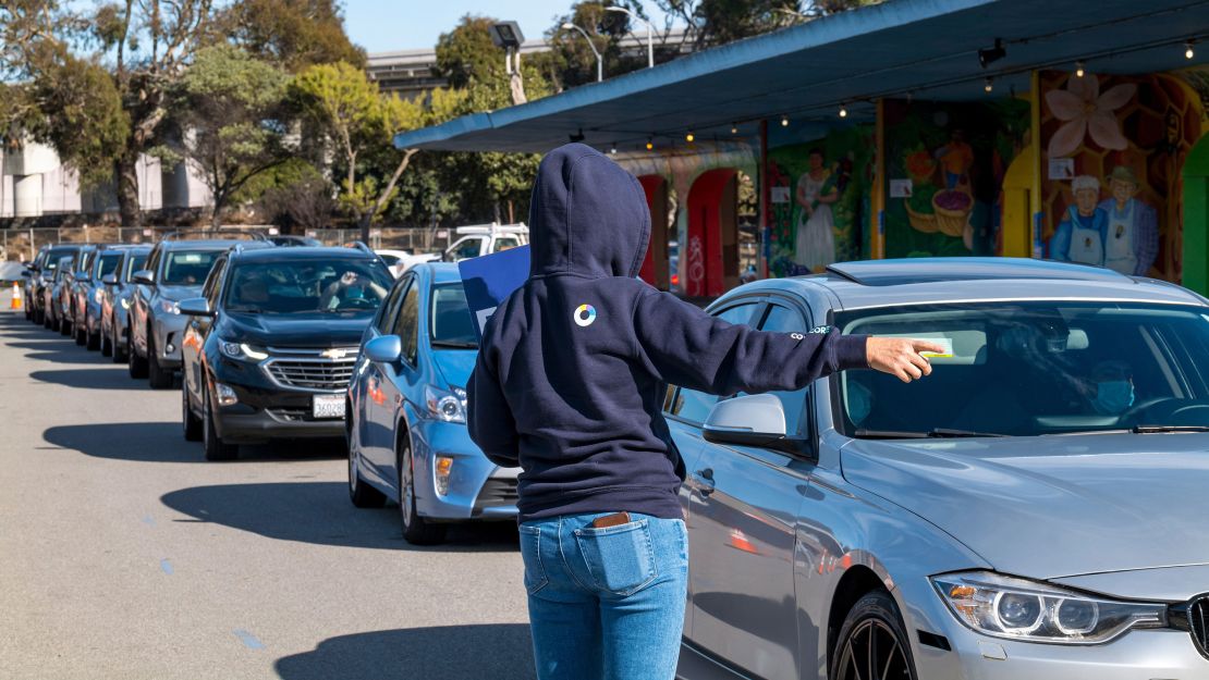 A worker directs traffic at a Covid-19 drive-thru testing site at the Alemany Farmers' Market in San Francisco on Thursday.