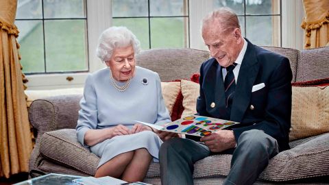 The Queen and Prince Philip look at a homemade anniversary card that was given to them by their great-grandchildren Prince George, Princess Charlotte and Prince Louis in November 2020.