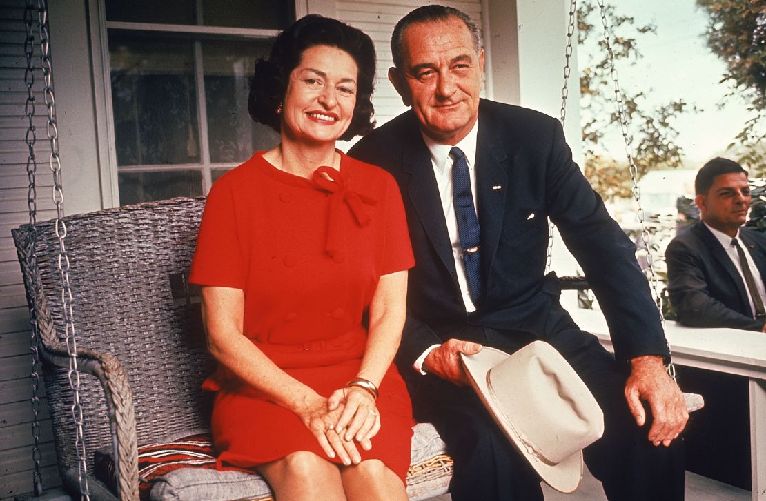 President Johnson sits on a porch swing with First Lady Lady Bird following his landslide election win. 