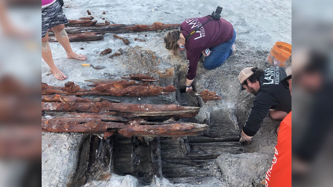 Dorothy Rowland and Nick Budsberg, both members of the St. Augustine Lighthouse Archaeological Maritime Program, examine the shipwreck on Crescent Beach.