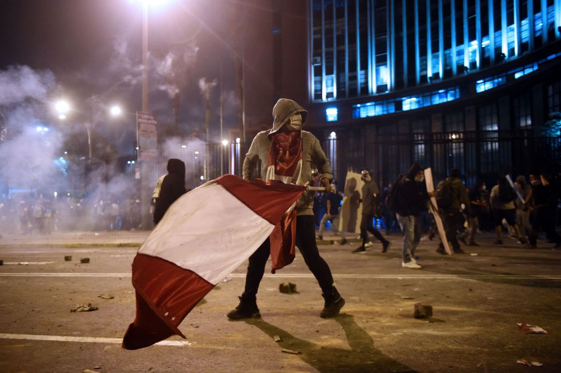 A demonstrator, supporter of Peruvian ousted President Martin Vizcarra, holds a Peruvian flag during clashes on November 14, 2020.