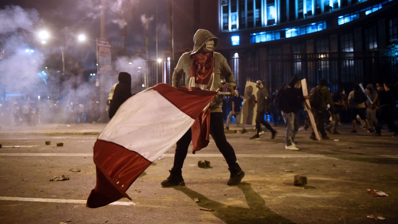 A demonstrator, supporter of Peruvian ousted President Martin Vizcarra, holds a Peruvian flag during clashes on November 14, 2020.