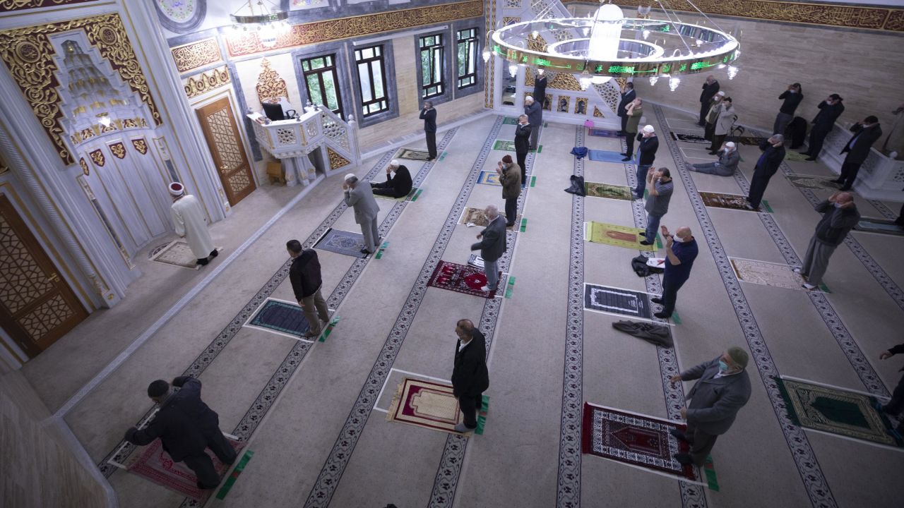 Muslims wearing protective masks perform Eid al-Fitr prayers at the Mevlana mosque in Berlin on May 24.