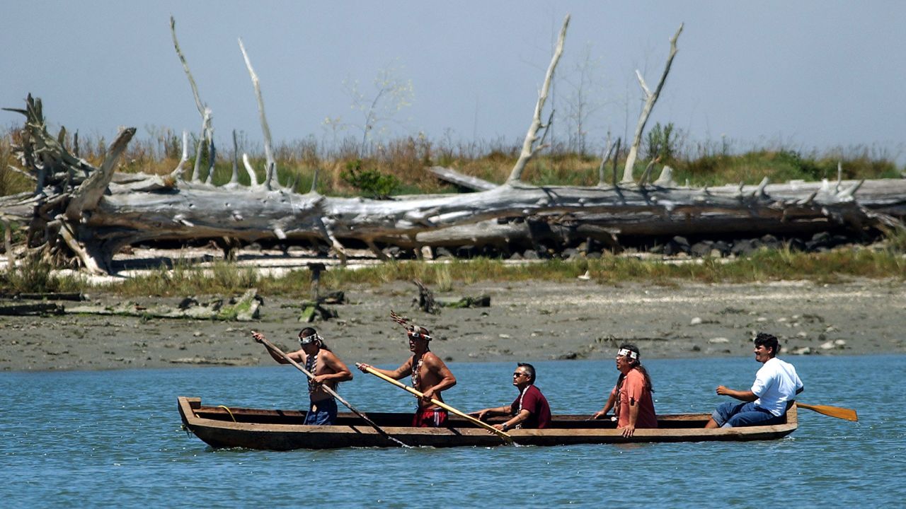 Members of the Wiyot tribe paddle a canoe from Duluwat Island across Humboldt Bay on June 25, 2004.