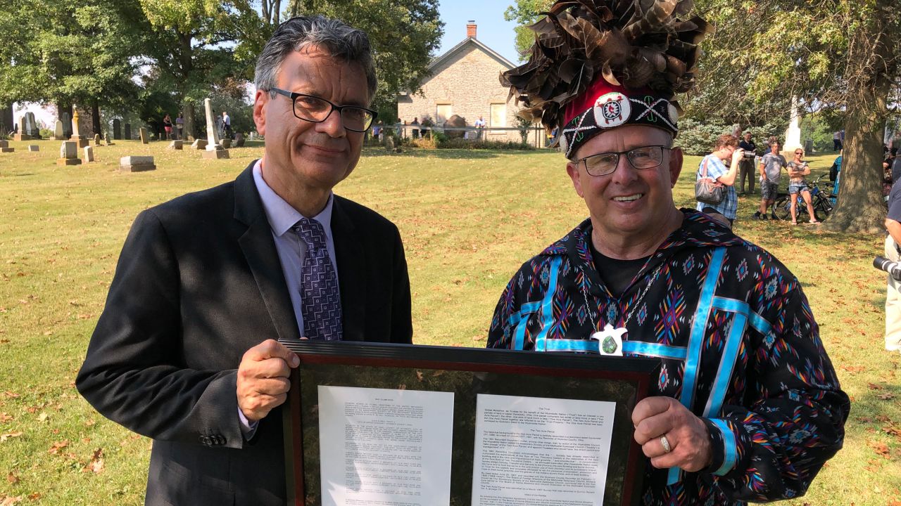 Thomas Kemper, the former general secretary of global ministries for the United Methodist Church, and Wyandotte Nation Chief Billy Friend hold a deed signifying the transfer of land to the tribe.