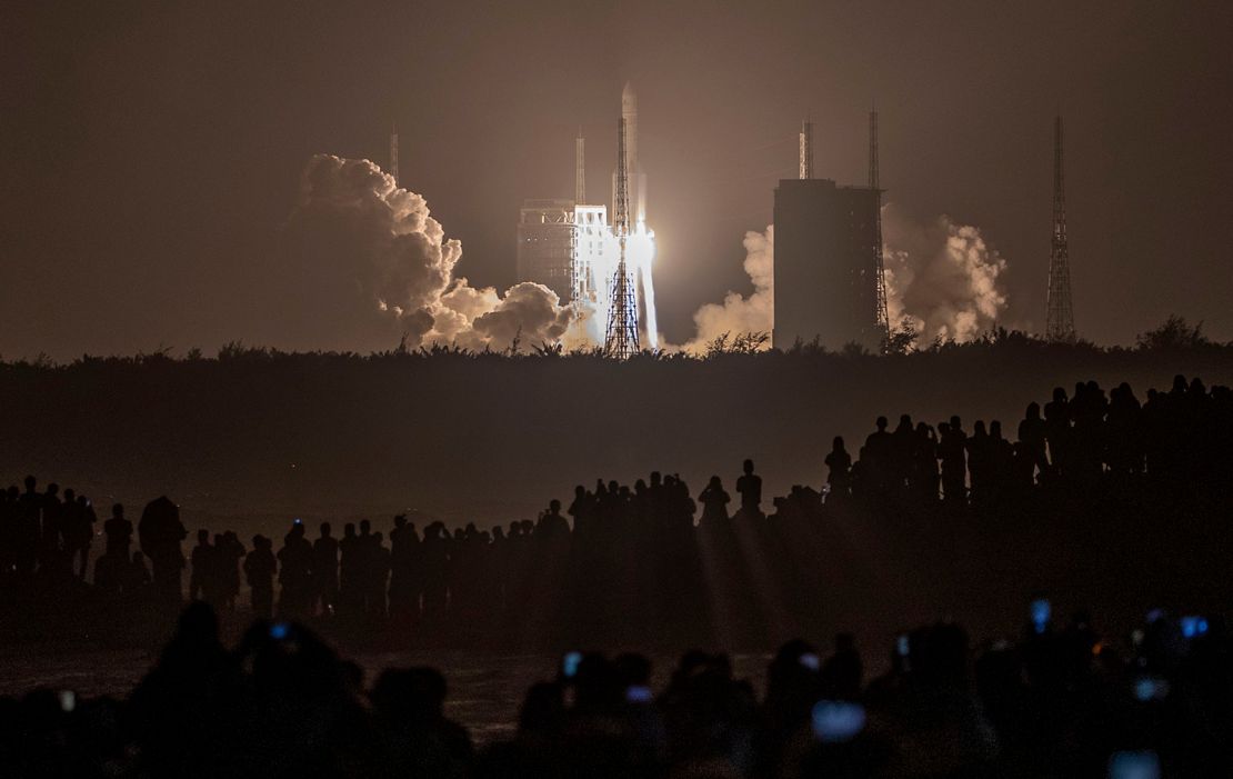 Crowds watch in the early hours of the morning as the rocket carrying Chang'e-5 launches. 