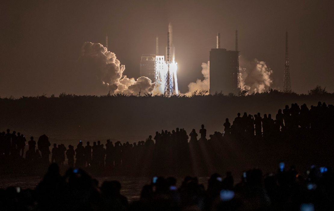 Crowds watch in the early hours of the morning as the rocket carrying Chang'e-5 launches.