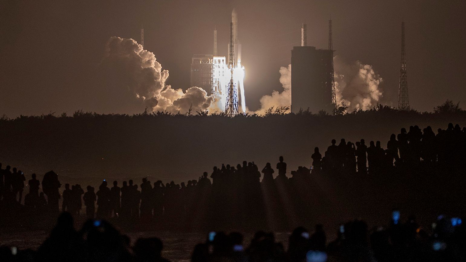 Crowds watch in the early hours of the morning as the rocket carrying Chang'e-5 launches. 