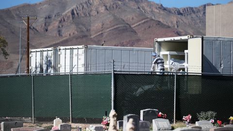 Inmates prepare to load bodies into a refrigerated trailer turned into temporary morgue in a parking lot of the El Paso County Medical Examiner's Office.
