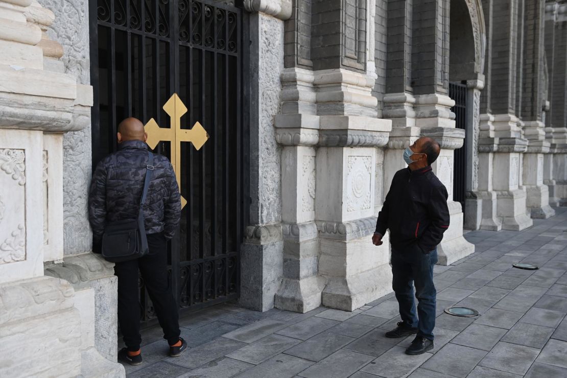 Two men look at St Joseph's Church, also known as Wangfujing Catholic Church, in Beijing on October 22, 2020.