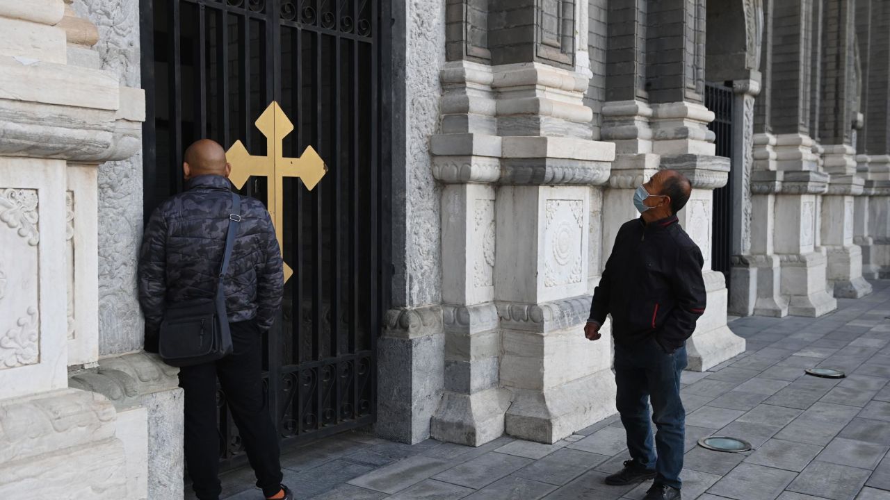 Two men look at St Joseph's Church, also known as Wangfujing Catholic Church, in Beijing on October 22, 2020.