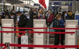 Travelers check in at O'Hare International Airport in Chicago on Wednesday. Despite warnings of health officials to stay home because of Covid-19, people are still traveling for the Thanksgiving holiday.