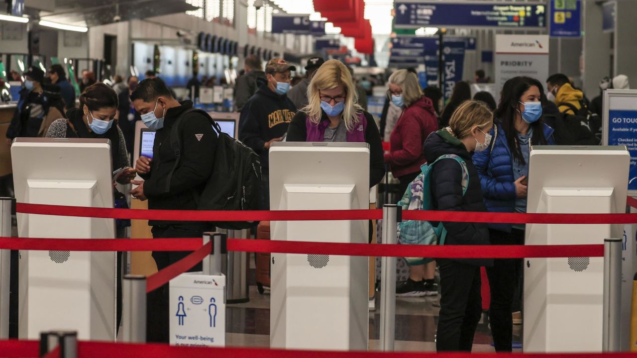 Travelers check in at O'Hare International Airport in Chicago on Wednesday. Despite warnings of health officials to stay home because of Covid-19, people are still traveling for the Thanksgiving holiday.