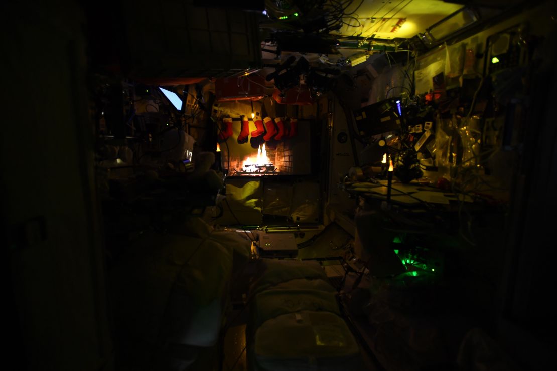 A festive yule log is projected on the space station.