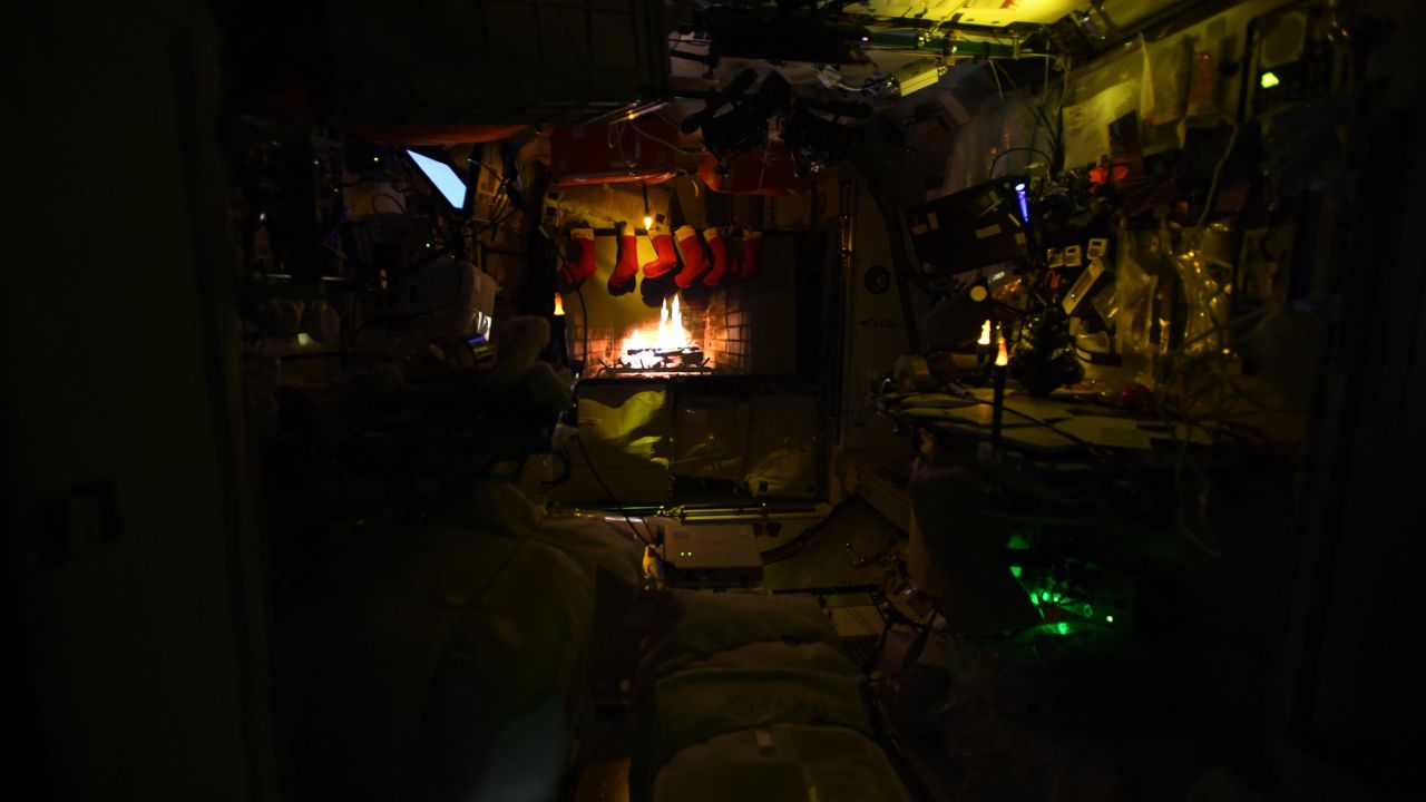 A festive Yule log is projected on the space station.