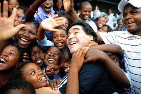 Maradona, as manager of Argentina's national team, is greeted by schoolchildren before the 2010 World Cup in South Africa.