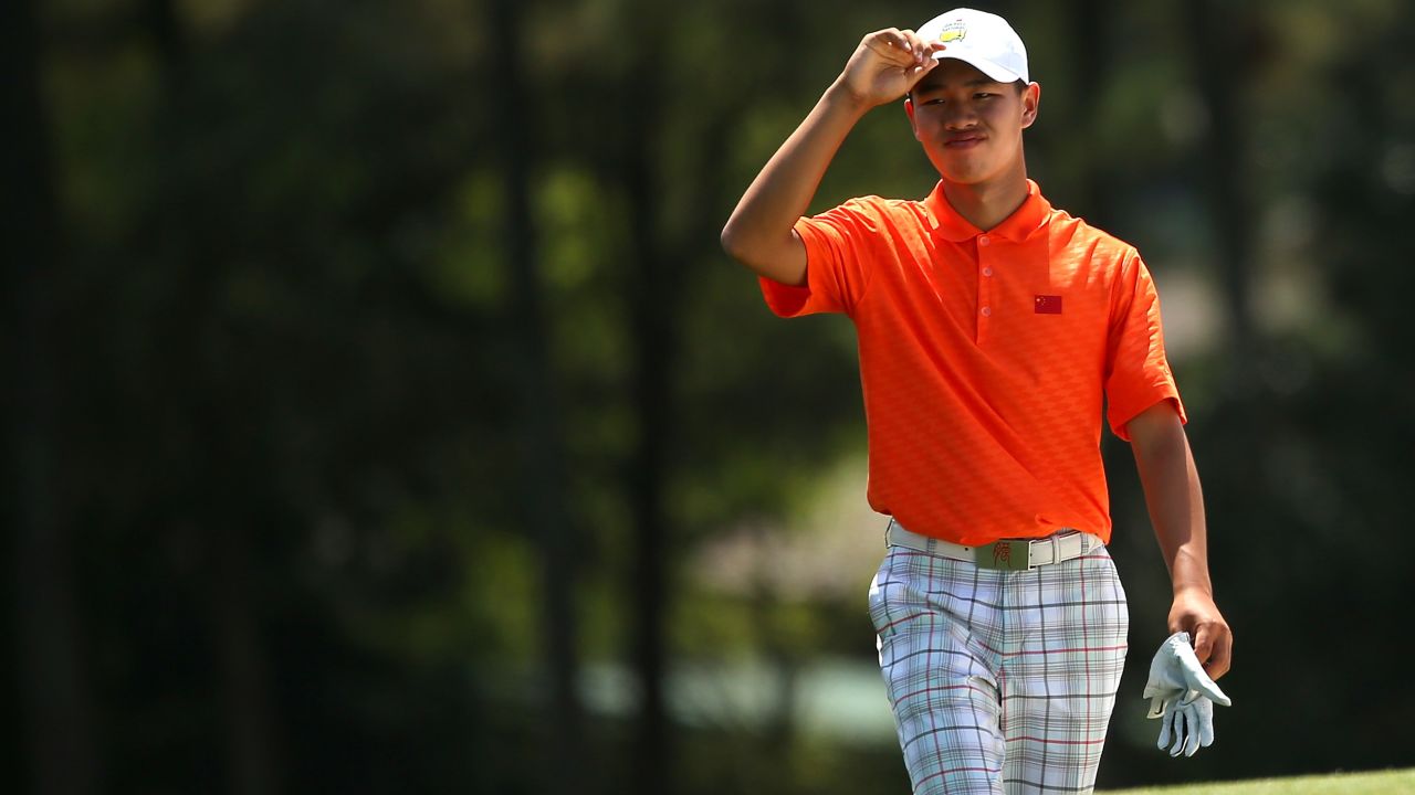Tianlang Guan walks up the 18th fairway during the second round of the Masters. Guan was given a one-shot penalty following his second shot on the 17th hole when he again exceeded the 40 second time limit.
