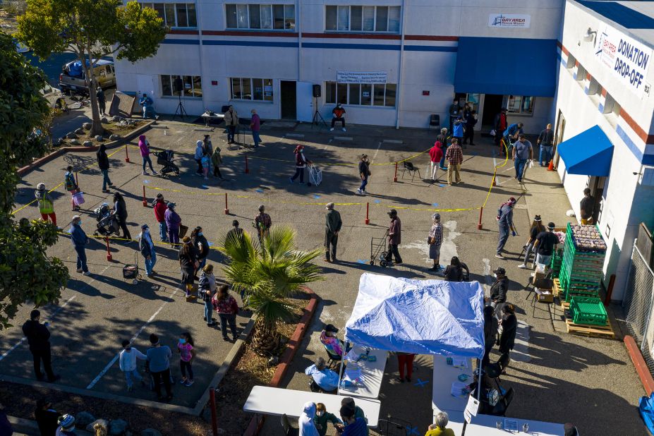 People wait in line to receive food at the Bay Area Rescue Mission's Thanksgiving Giveaway in Richmond, California.