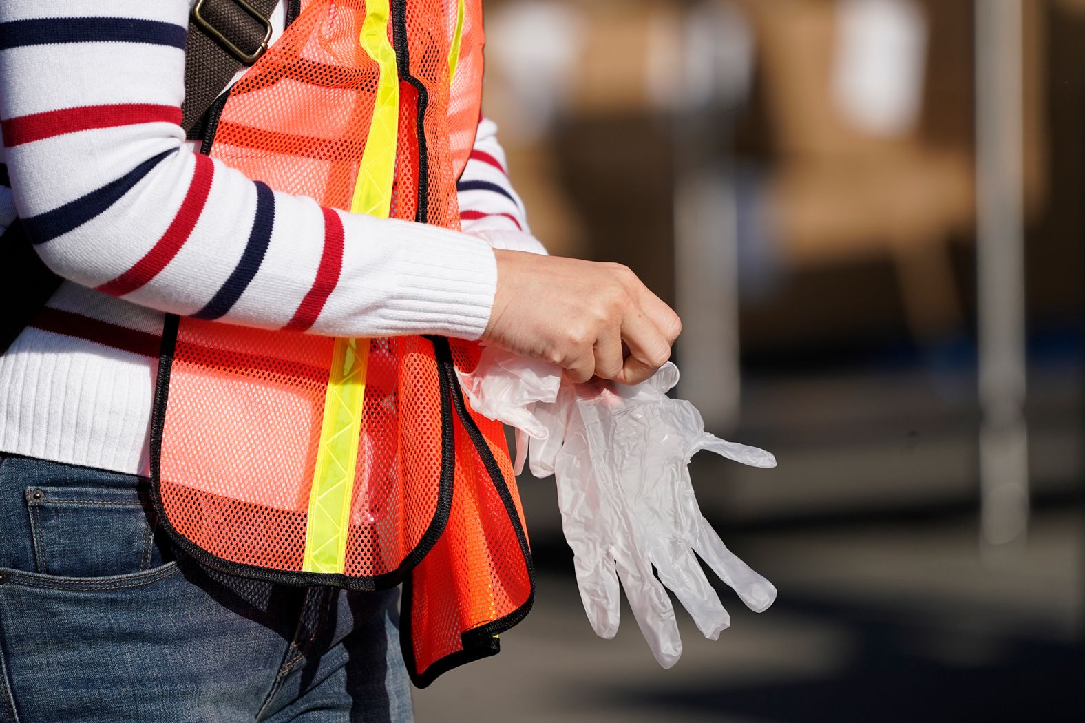 A volunteer puts on gloves before packing boxes of food outside the Second Harvest Food Bank in Irvine, California, on November 19.